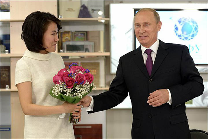 Vladimir Putin surprises a female Siberian student with flowers on her 23rd birthday but also comes face to face with a woolly mammoth
