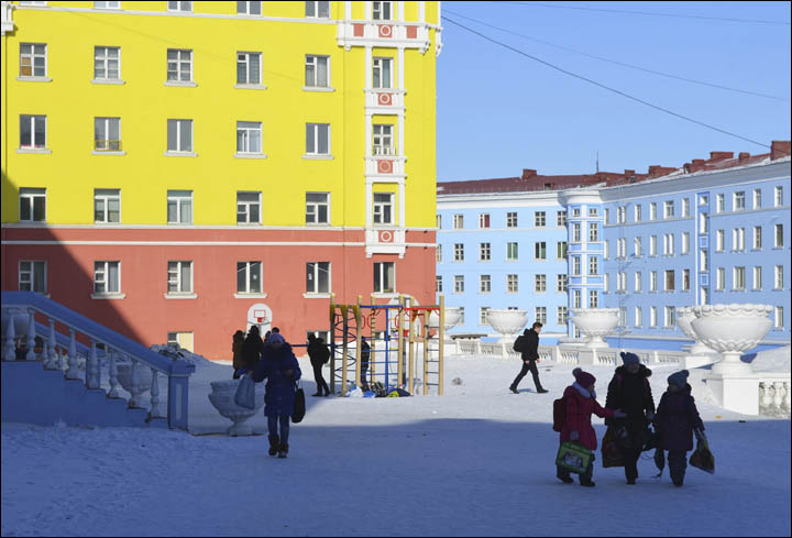 Children walking along colorful buildings